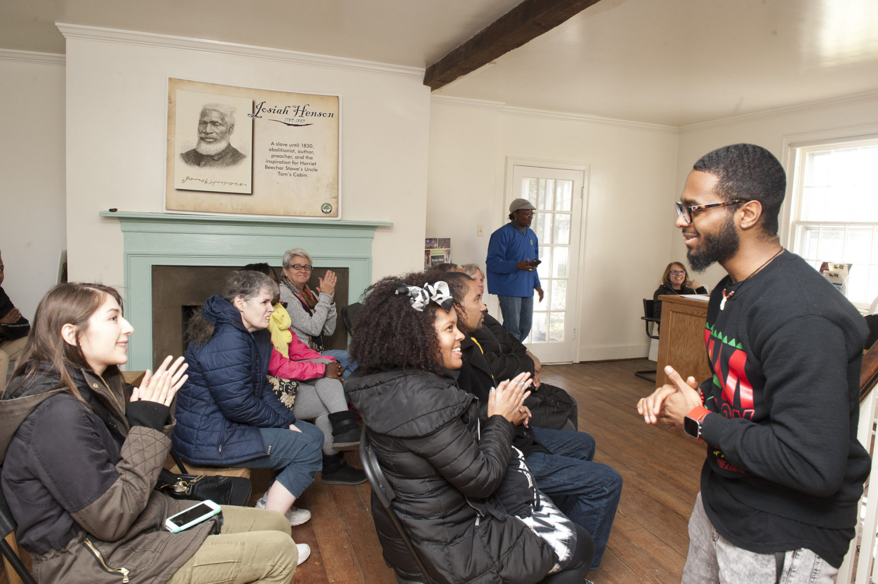 A young man walks back towards seats after performing a Spoken Word Poetry piece