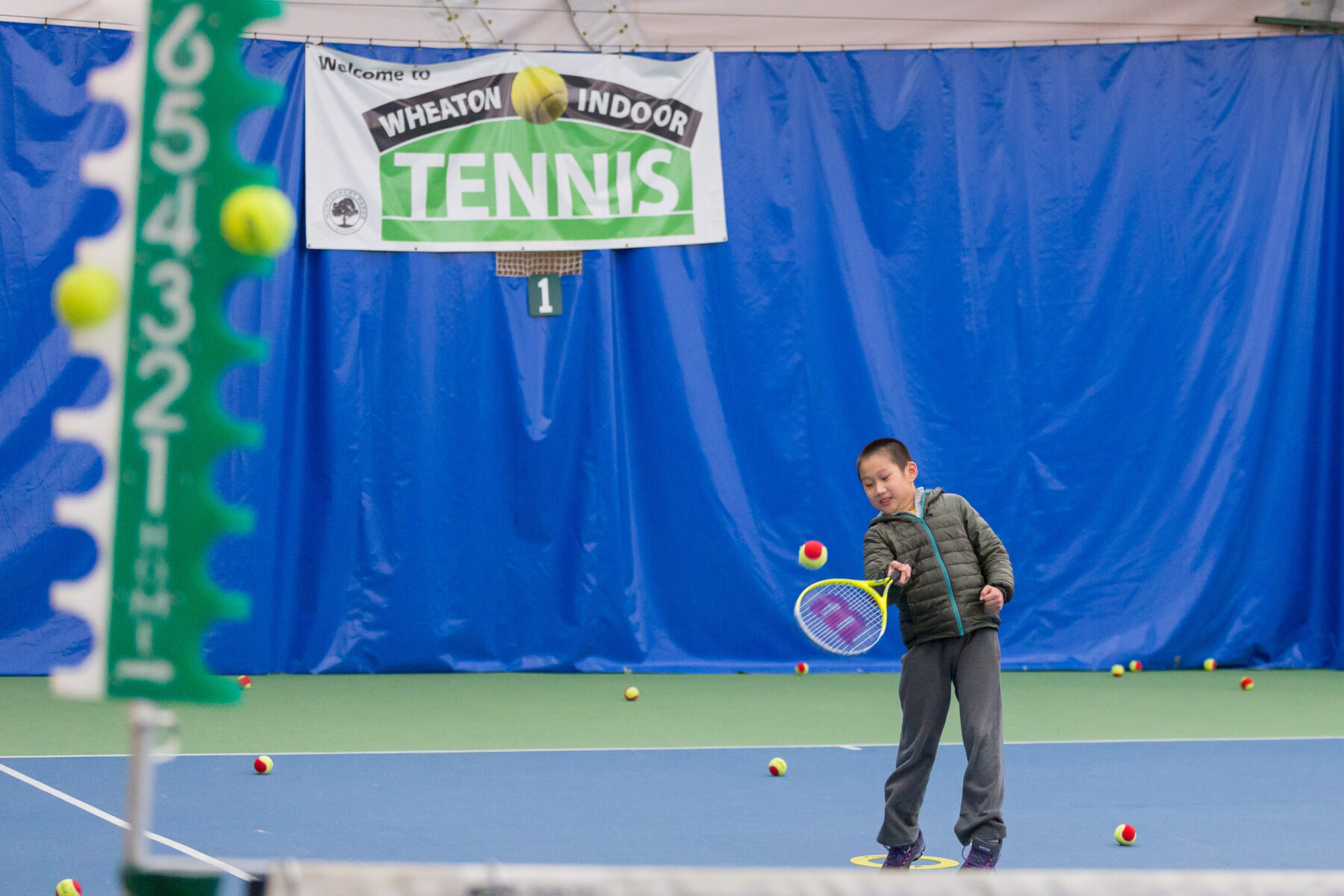 Child playing tennis at Wheaton Indoor Tennis.