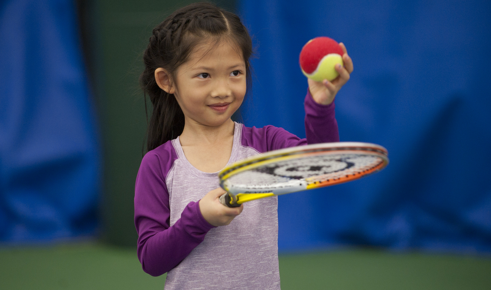 Young female tennis enthusiast practices at Pauline Betz Addie Tennis Center.