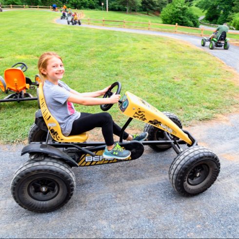 A young girl smiles for the camera in a pedal kart at Little Bennett Campground