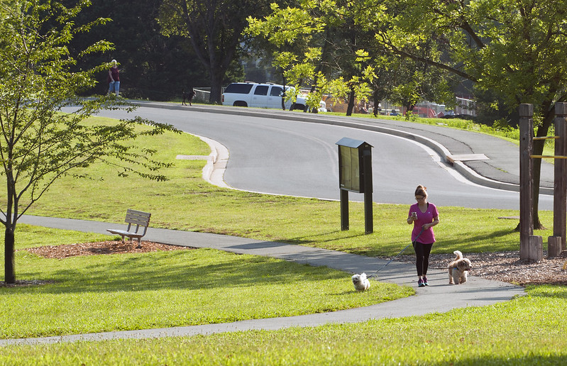 A person walking two dogs on the HeartSmartTrail at Martin Luther King Jr. Recreational Park