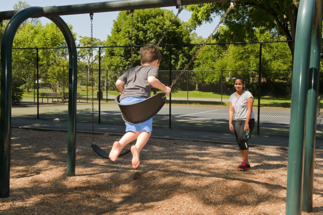 Child swinging on a swing set Montgomery Hills Neighborhood Park