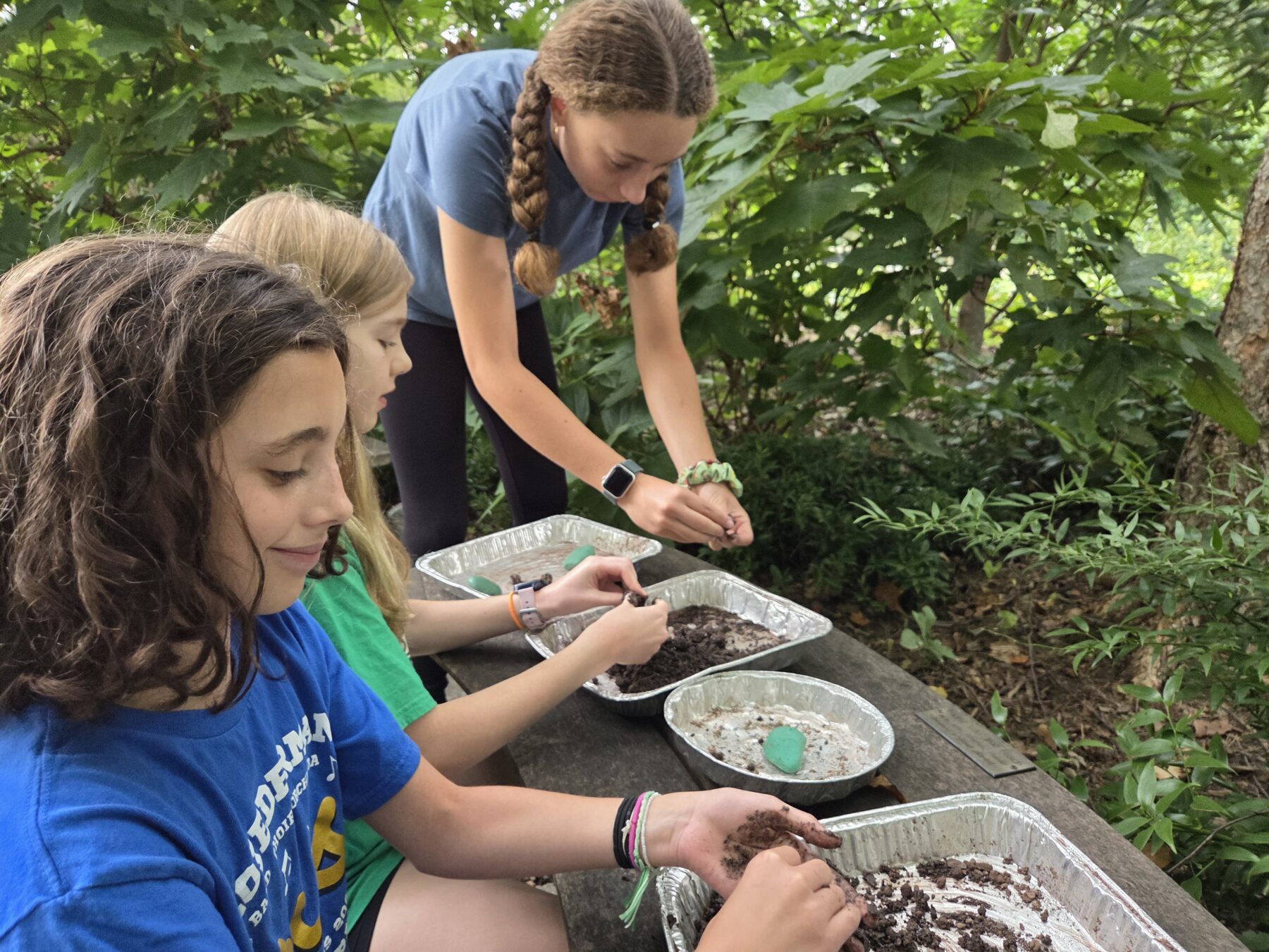 Youth participants making native seed balls on a field trip