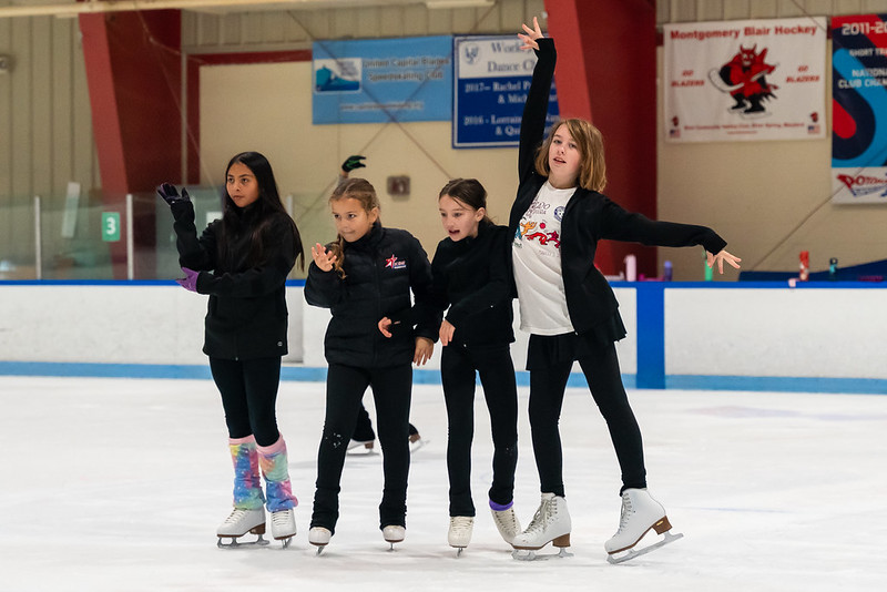 Four skaters dancing to music on the ice