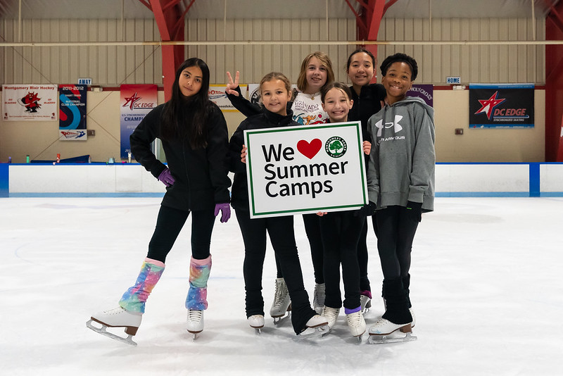 Group of skaters holding a sign saying "We love summer camps"