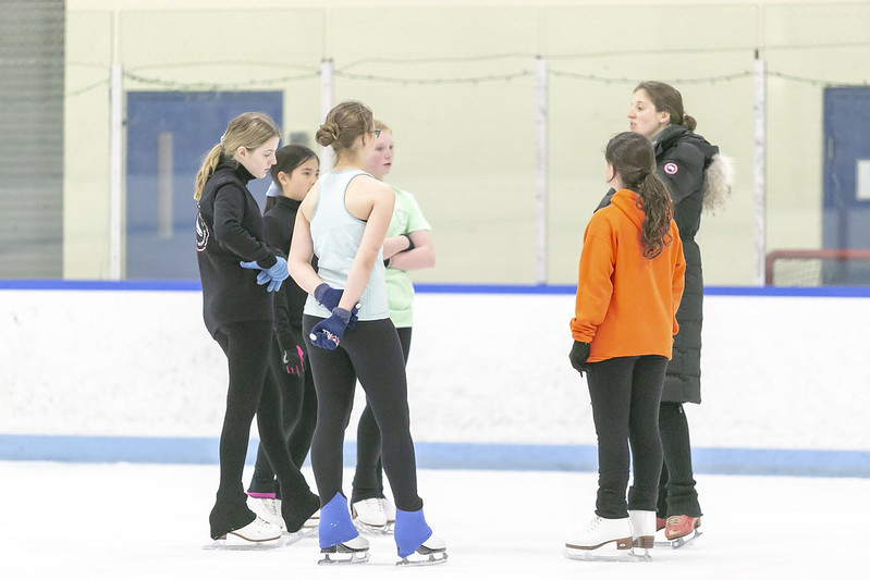 coach speaking with figure skaters