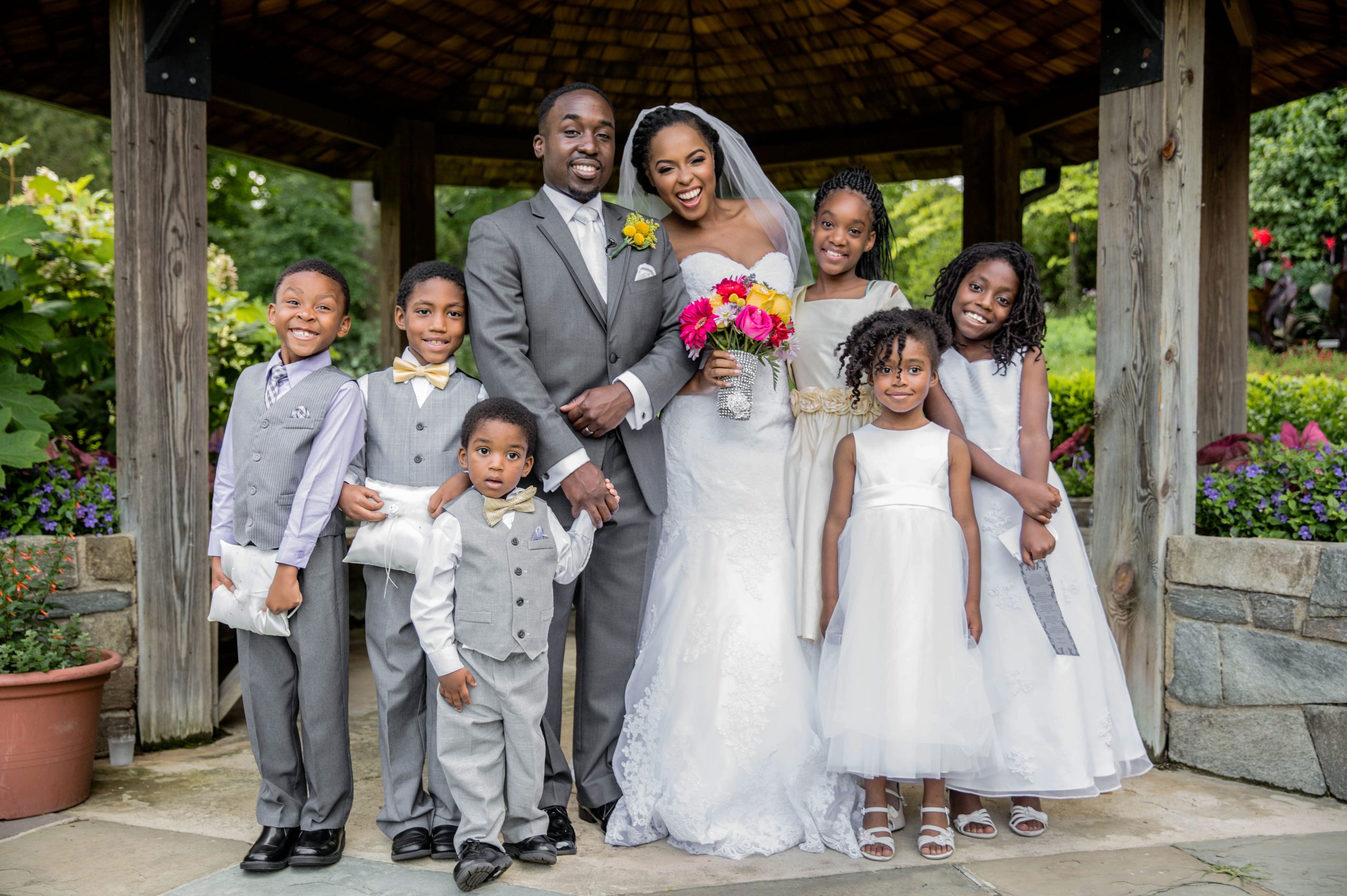 A bride and groom surrounded by young ring bearers and flower girls.