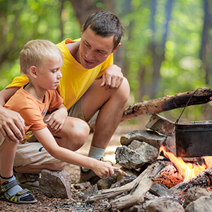 A father and child at a campfire.