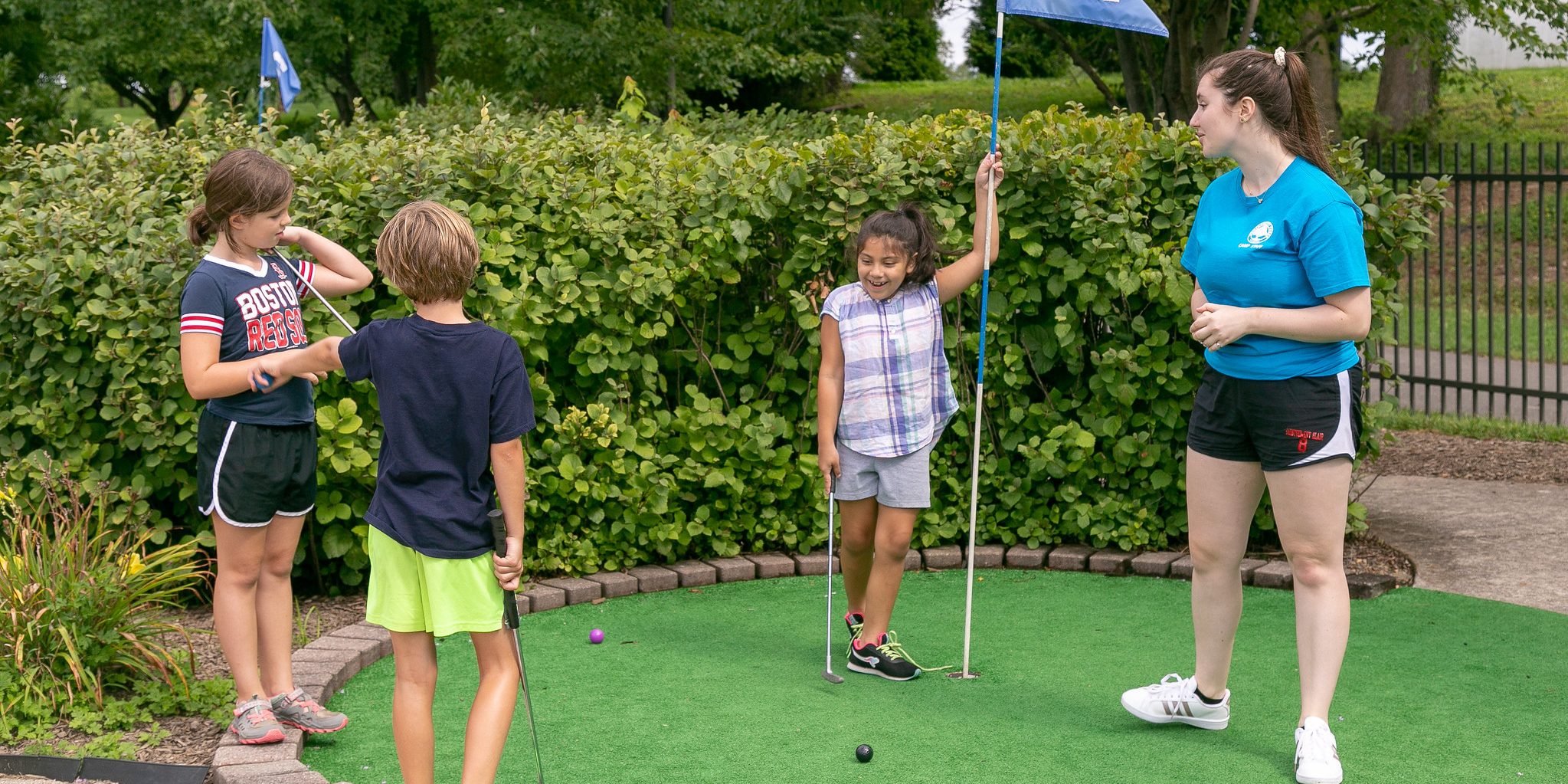 Kids playing mini-golf.