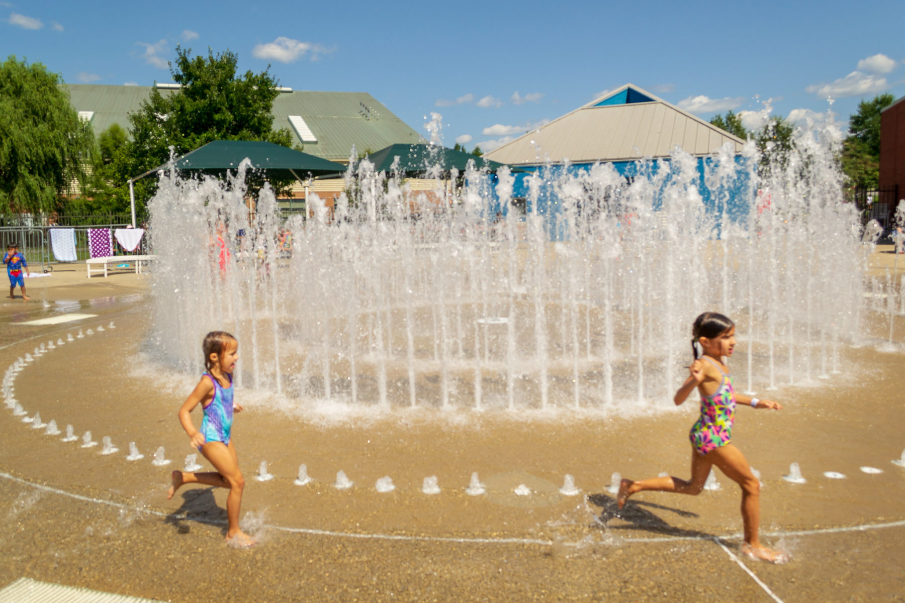 Two children running in front of water maze at the SplashPark