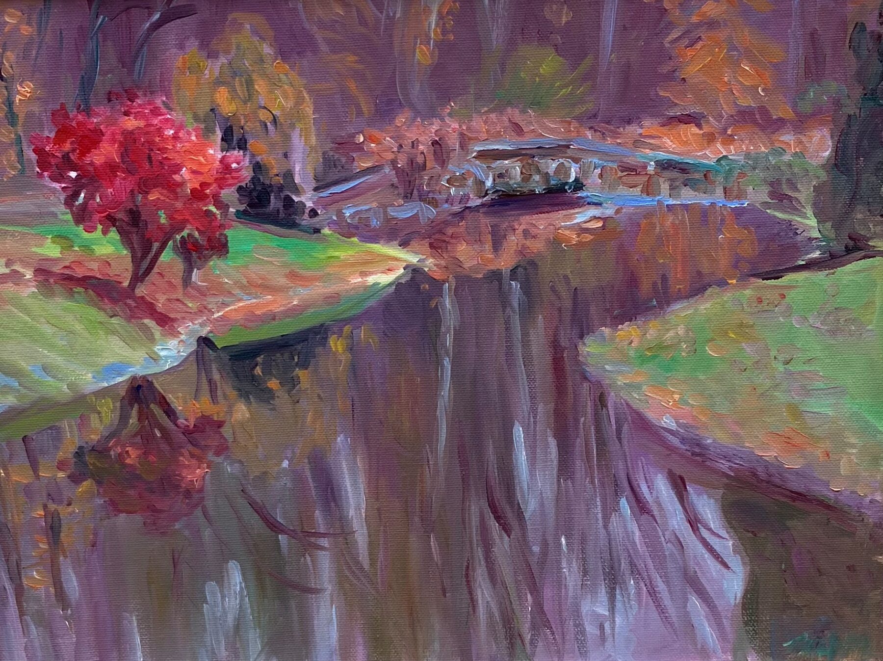 The rectangular oil on canvas painting features an abstract distant bridge goiing over a reflective body of water flanked by green. On the left bank is a vibrant tree with a brown trunk and bright red and dark red folliage. On the right bank features a dark green tall tree with no visible trunk.