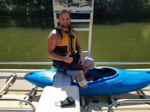 Man sitting next to kayak