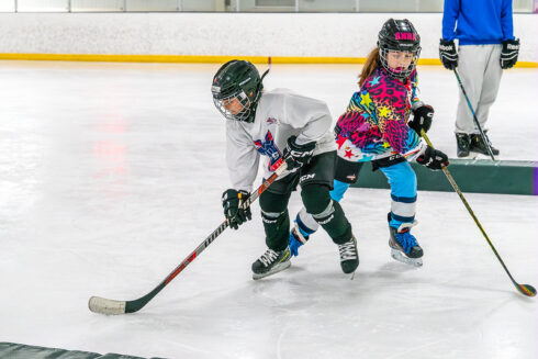 Two girls playing hockey