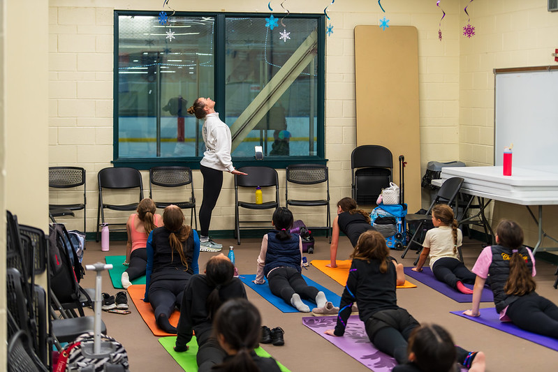 Mariah leading a group of skaters in stretching