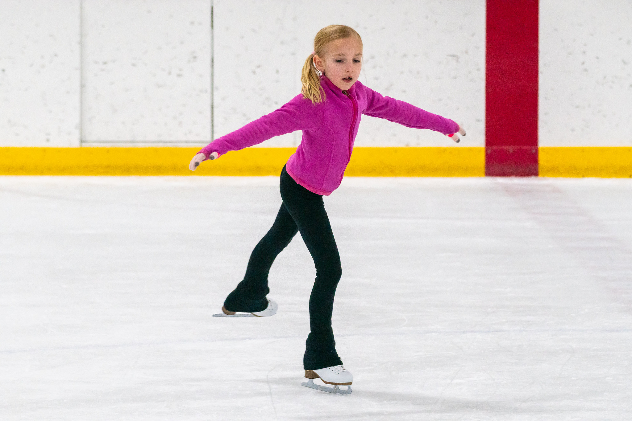 child learning beginning moves of an ice skating jump