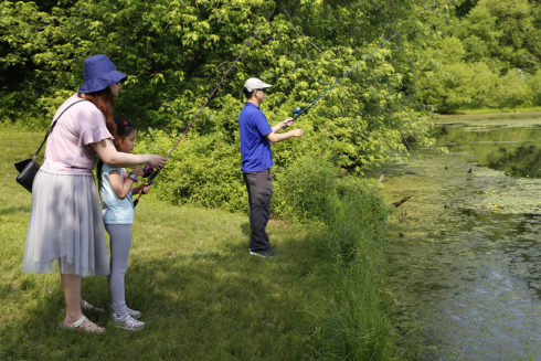 family of three fishing at a lake