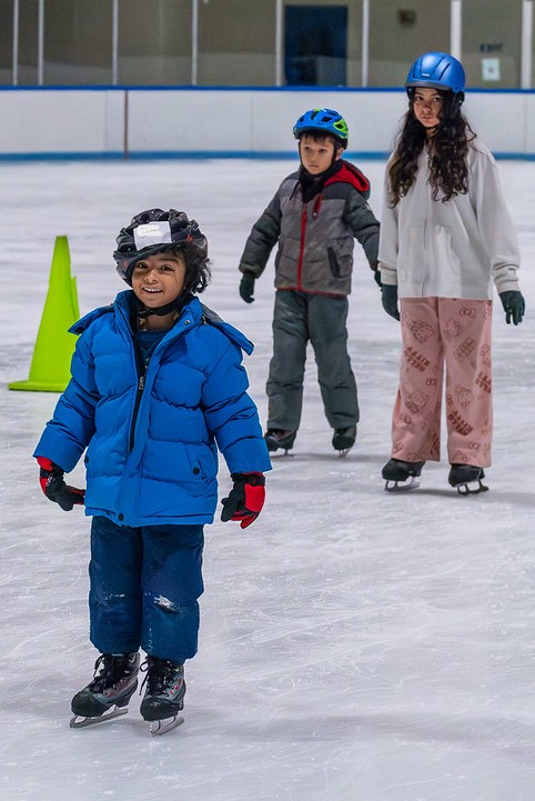 Children ice skating and smiling
