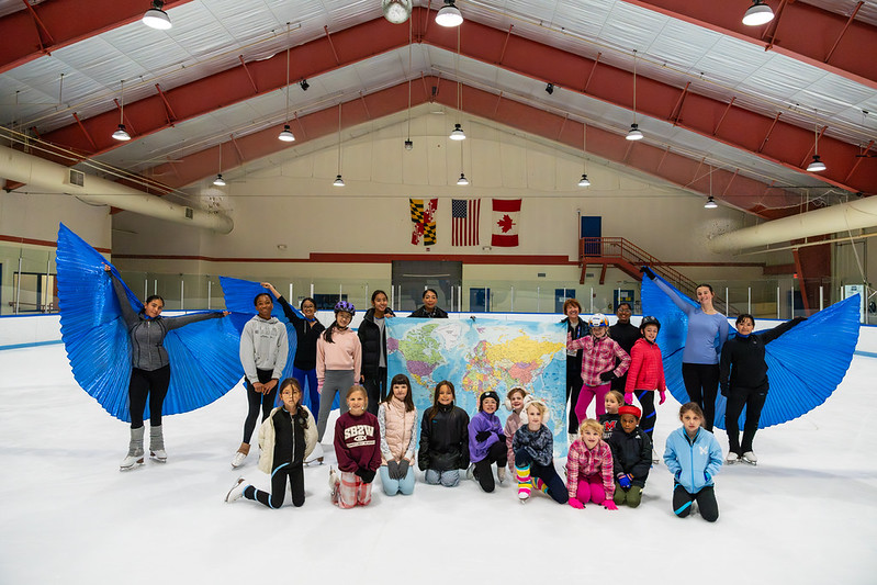 Theater on ice campers posing with a map