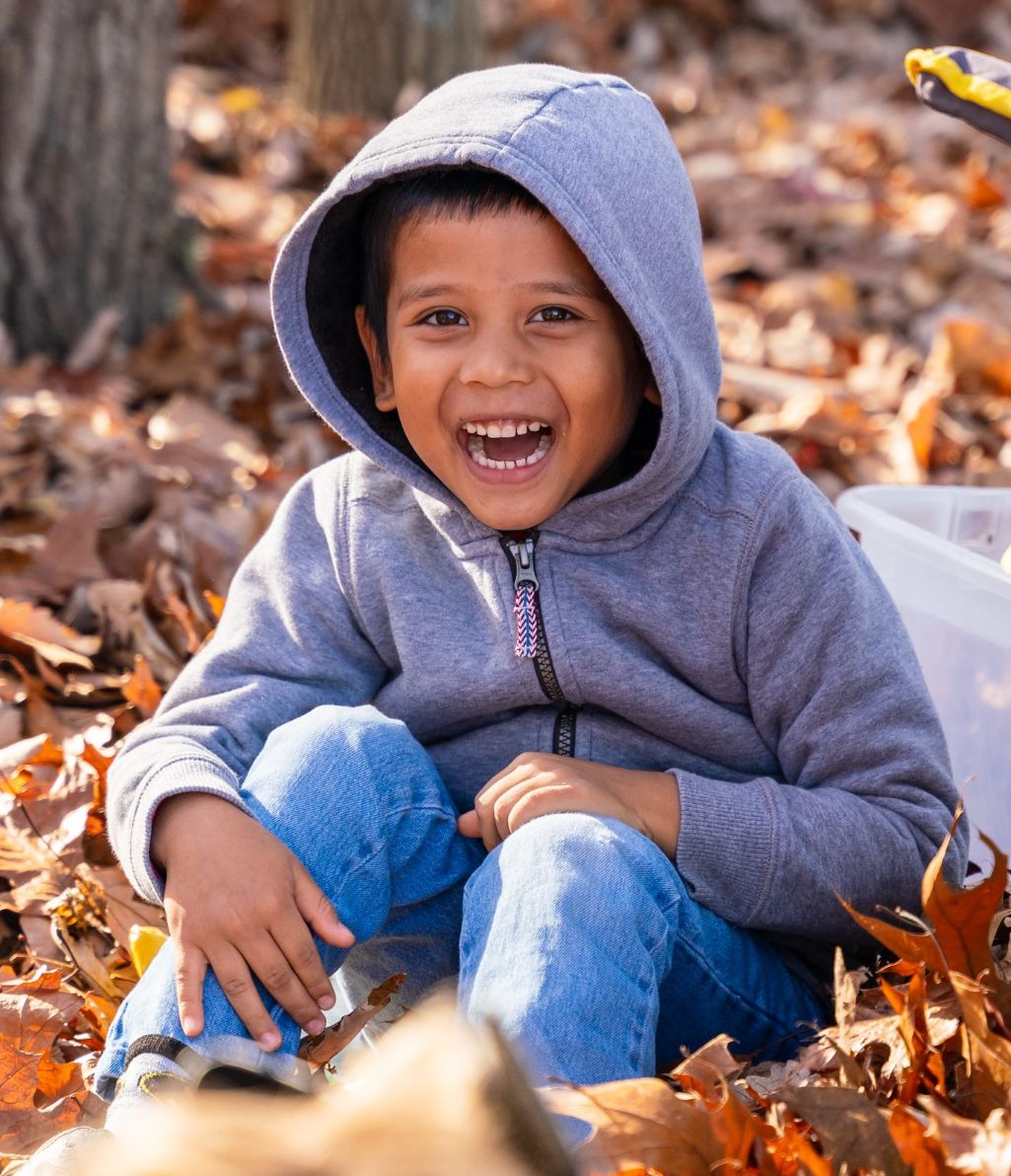 child playing in leaves