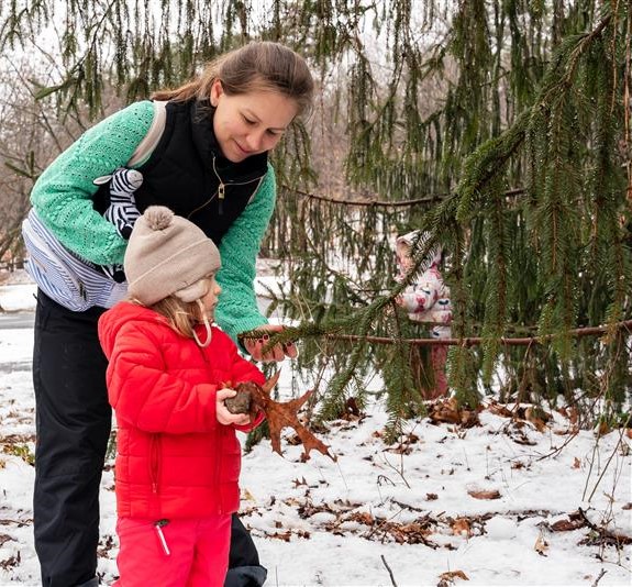 Adult and child playing in snow.