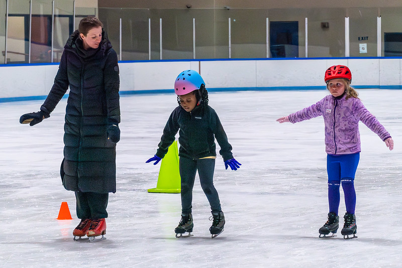 Ice skating coach with two skating students