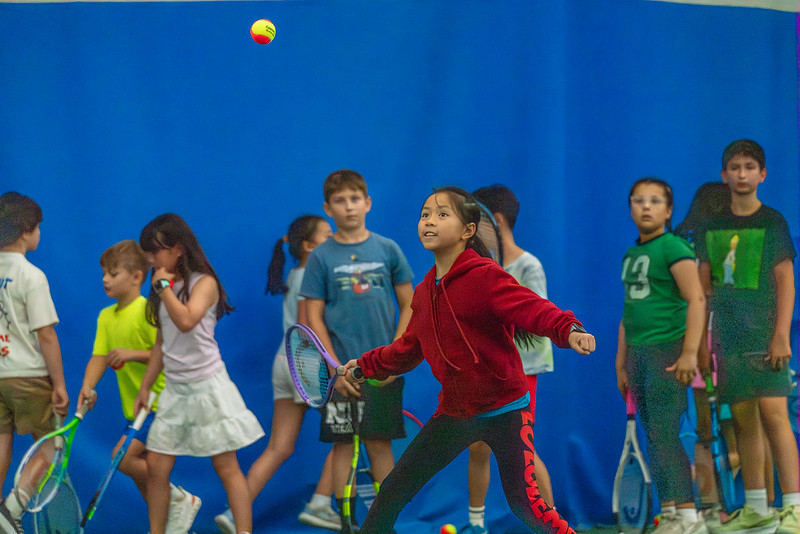 Girl hitting a ball at tennis camp
