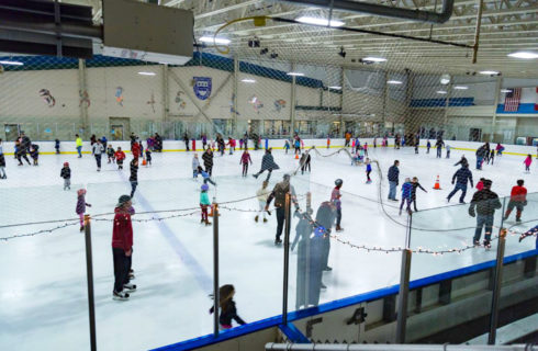 Adults and children ice skating during a public skating session at one of Montgomery Parks' indoor ice rinks.
