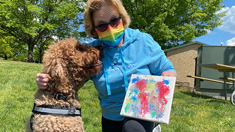 Woman posing with her dog with their new artwork