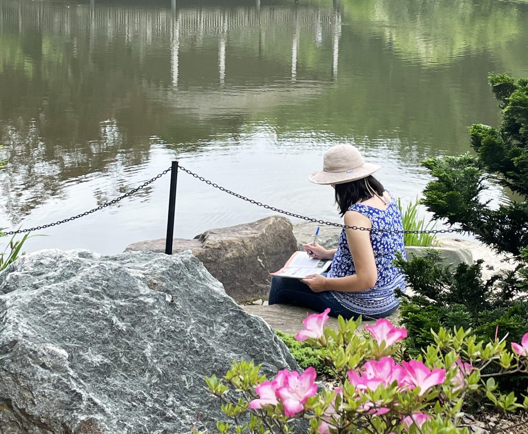 A woman sitting next to a pond