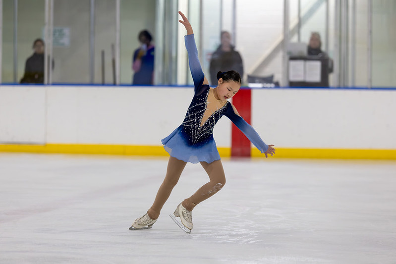 Skater in blue dress performing in the ice show