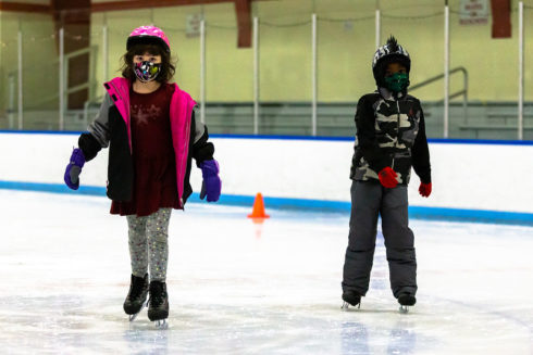 Two kids skating at Wheaton Ice Arena.
