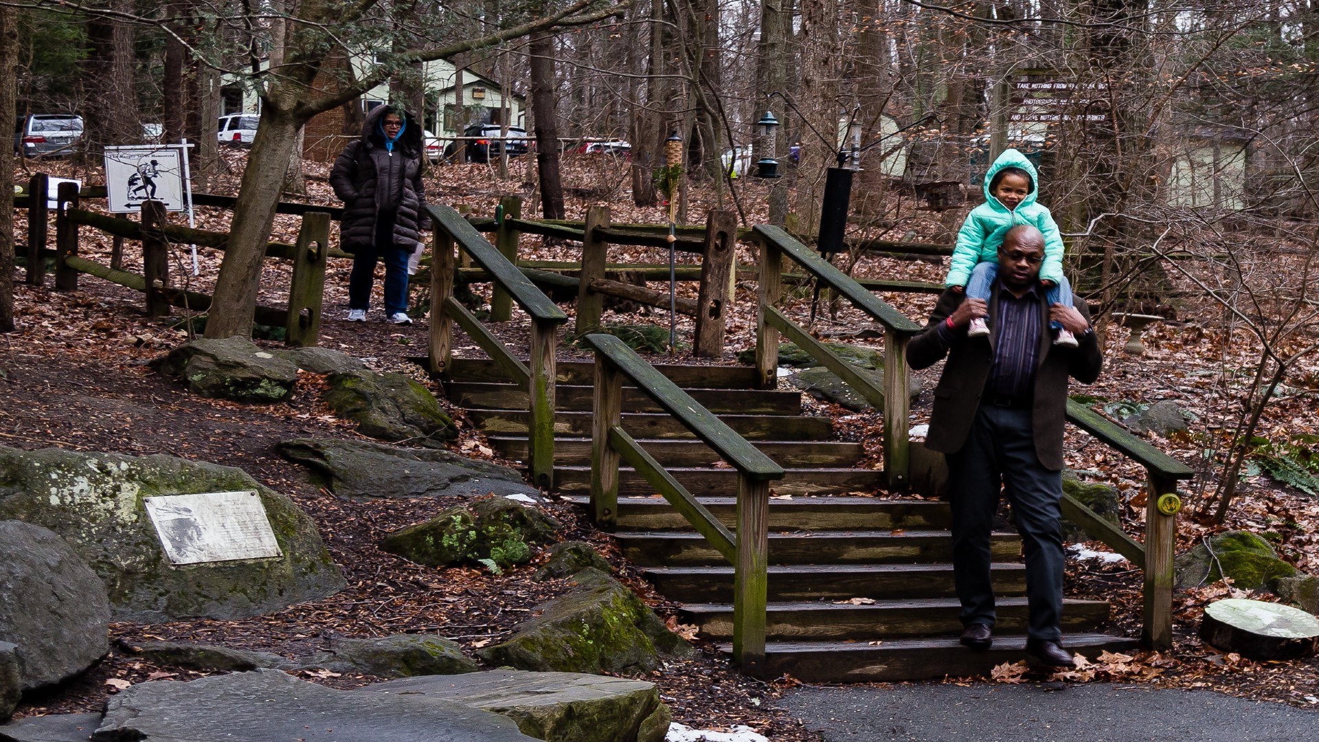 A family descends a staircase coming from a trail walk
