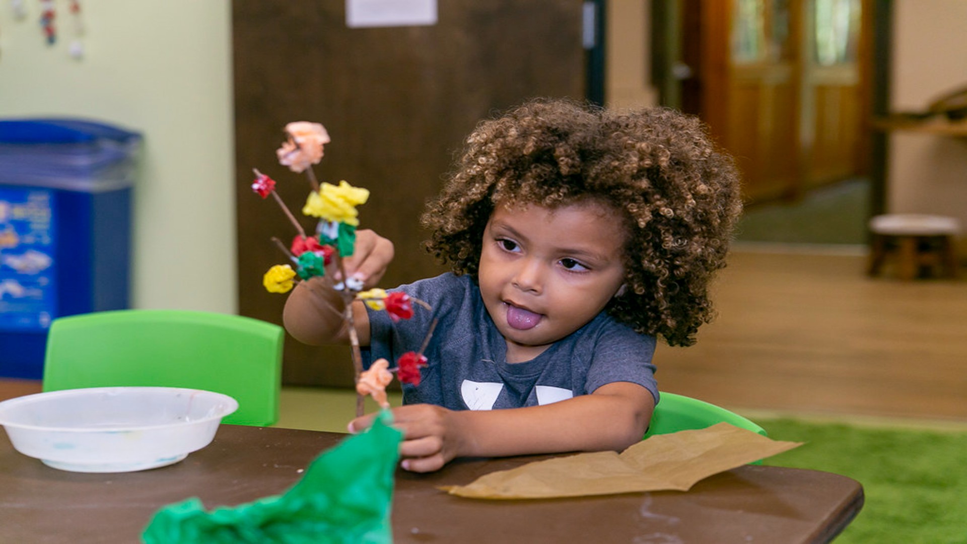 A child makes a tree during an arts and craft activity