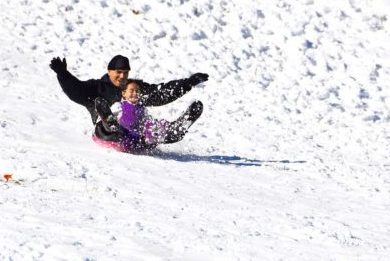 man and girl sledding