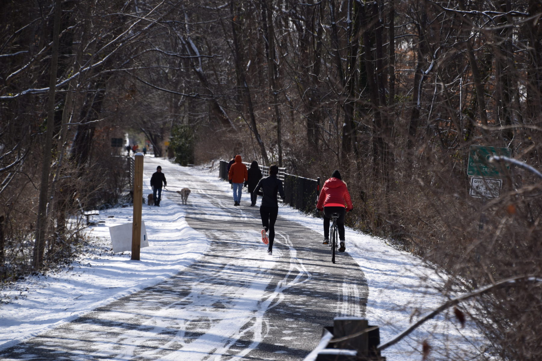 People recreating on a snow paved road.