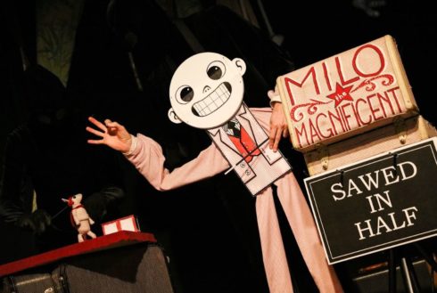 Milo the Magnificent puppet leans over a table with a small mouse on it. Sign to his right has his name and the text "Sawed in half."