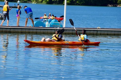 Two people paddling in a double kayak on Little Seneca Lake.