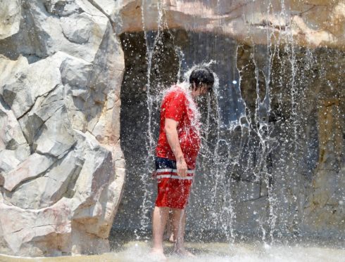 A boy stands beneath the waterfall feature at South Germantown SplashPark and MiniGolf.