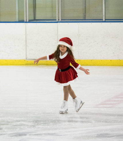 girl in santa hat ice skating