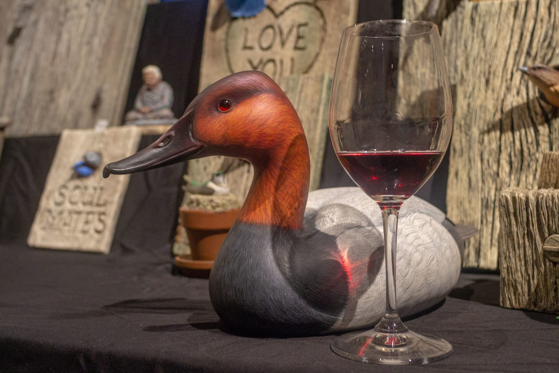 Photo showing duck decoy and a glass of wine.