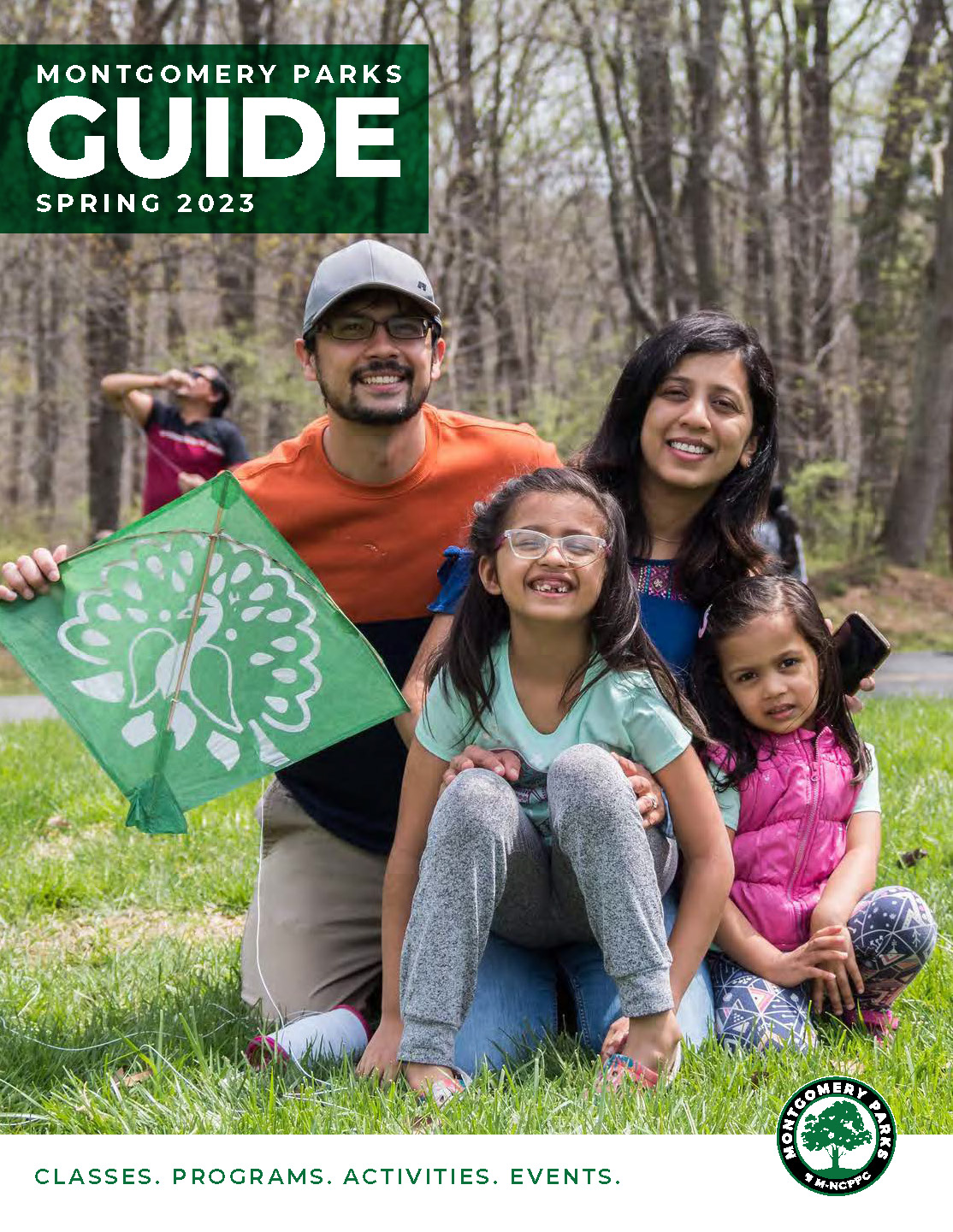 Montgomery Parks Guide Spring 2023. A family poses for a photograph in a park.