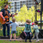 past acoustics and ales performer ted garber performing and little kids dancing around him