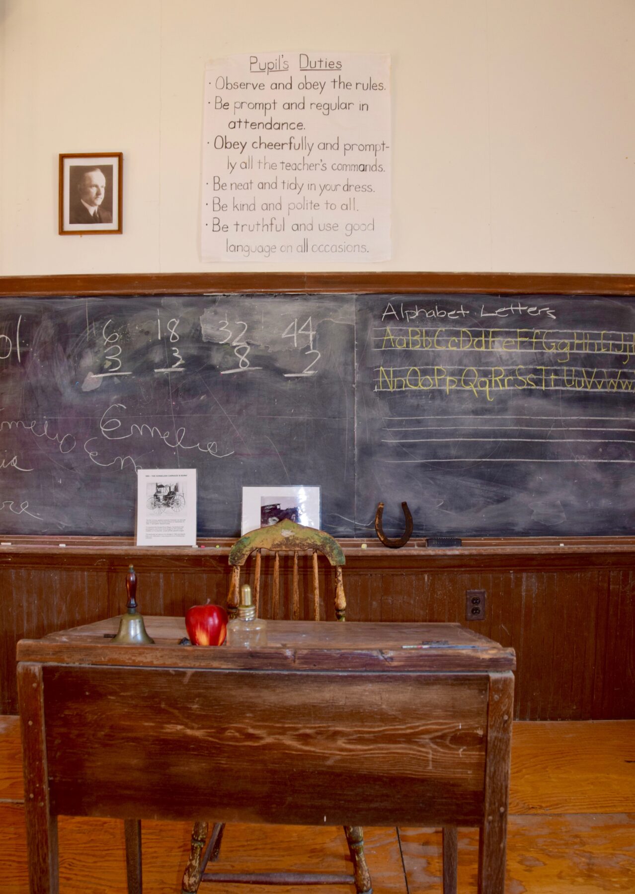 Chalkboard, teacher's desk with an apple on top, interior of Kingsley Schoolhouse.