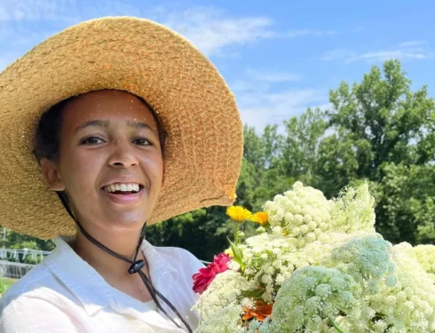 Farmer Nia holding a bucket of flowers