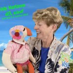 val smalkin and silly goose looking at each other and smiling in front of a beach backdrop