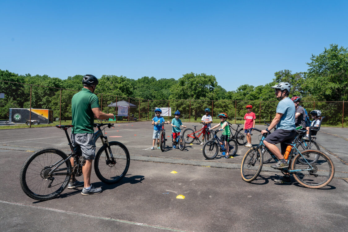 A bike instructor leads a group of youth on bikes