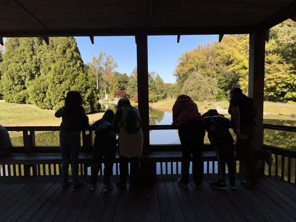 Group of trail trekkers participants looking over railing into water at brookside gardens