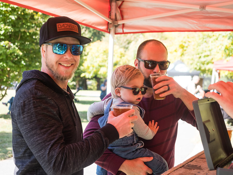 two men and young child at beer vendor