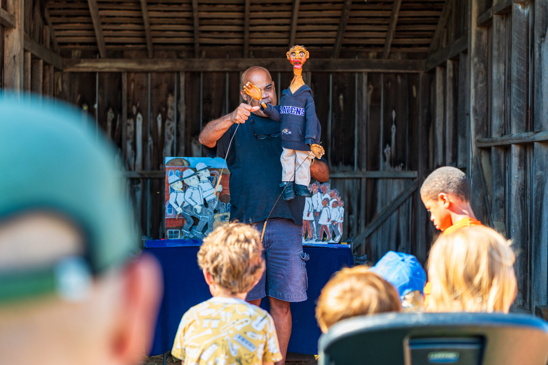 Man holding puppet in front of a  crowd of children