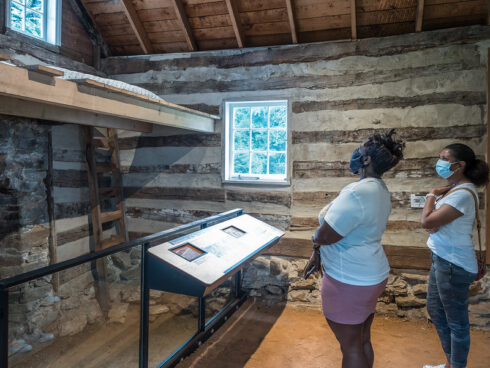 Visitors inside the historic log kitchen at the Josiah Henson Museum and Park